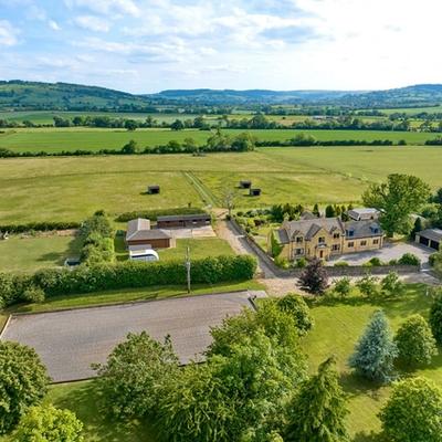 Aerial view of a cotswolds house surrounded by farm land