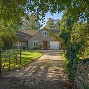 An open gate leads to a private country house with dry stone walls