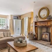Living room with traditional fireplace and circular mirror